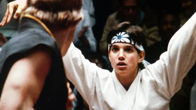 Un giovane allievo si allena nel karate sotto la guida del suo maestro