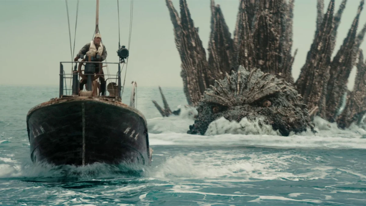 Scena cinematografica evocativa con una creatura gigante davanti allo skyline di una città
